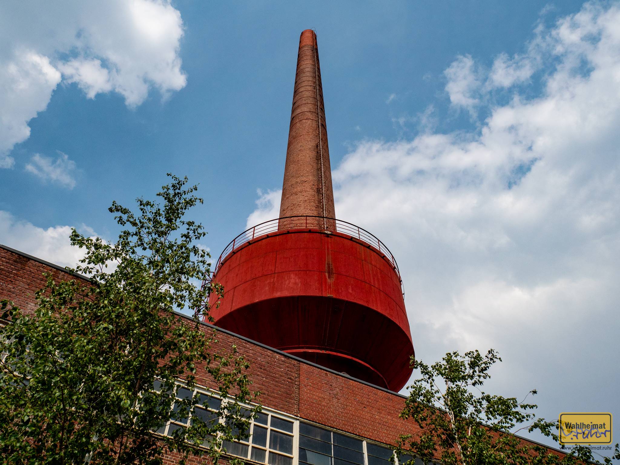 In Krefeld ragt dieser rote Koloss am Kesselhaus 70m in die Höhe. Weithin sichtbar fungiert er als eine Art Wahrzeichen des Mies van der Rohe Business-Parks.